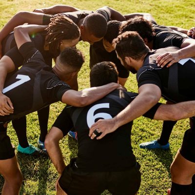 Rugby, team and huddle together for exercise, motivation and game field for match preparation. Above sports, fitness and group of men outdoor with competition planning, club and practice with talk.
